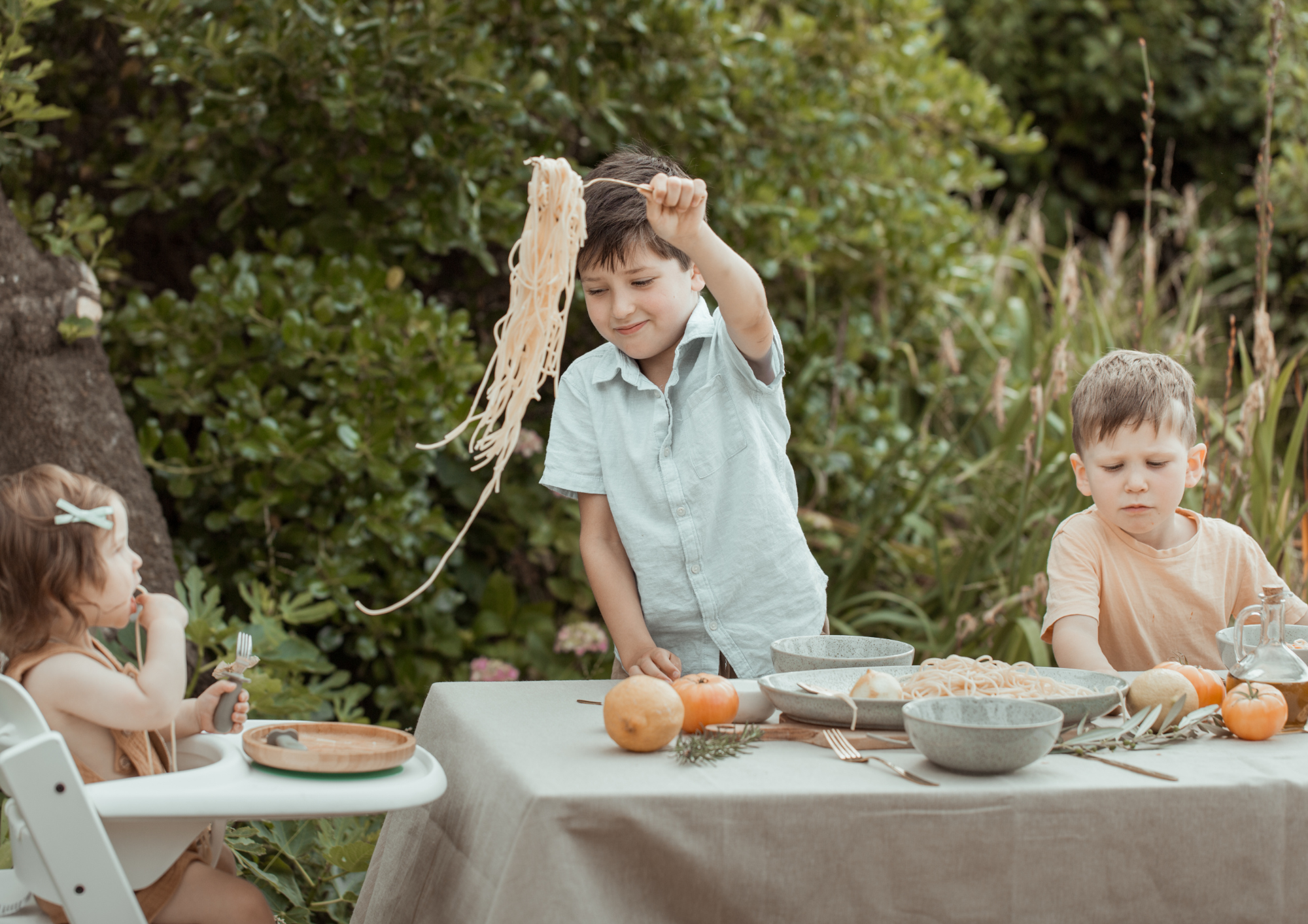 Child serving baby spaghetti on a picnic table. Abby McLennan Mum Bub Nutrition